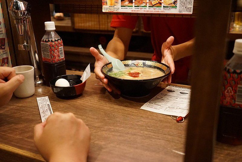 Ramen being served up from behind a clear divider at Ichiran