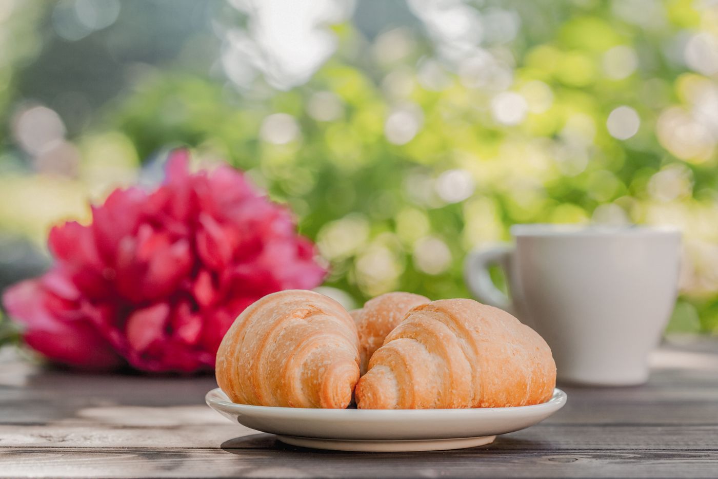 Croissants et café posés sur une table en terrasse, petit-déjeuner à la française